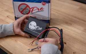 A person is holding wires in front of a box.