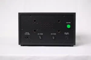 A black box with green button and a green light